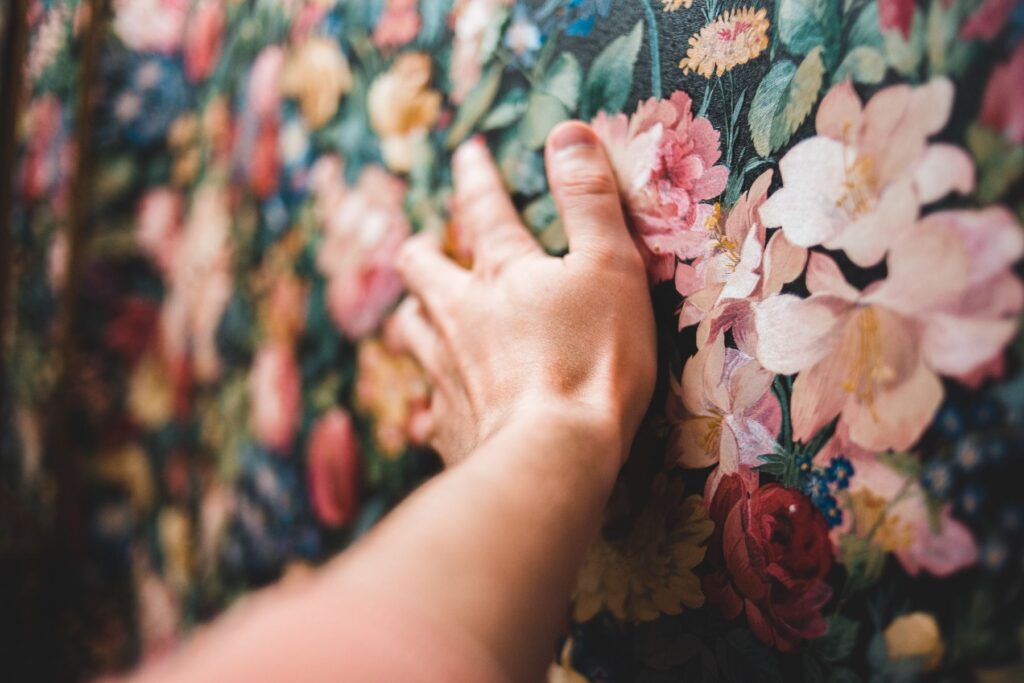 Hand on old wallpaper